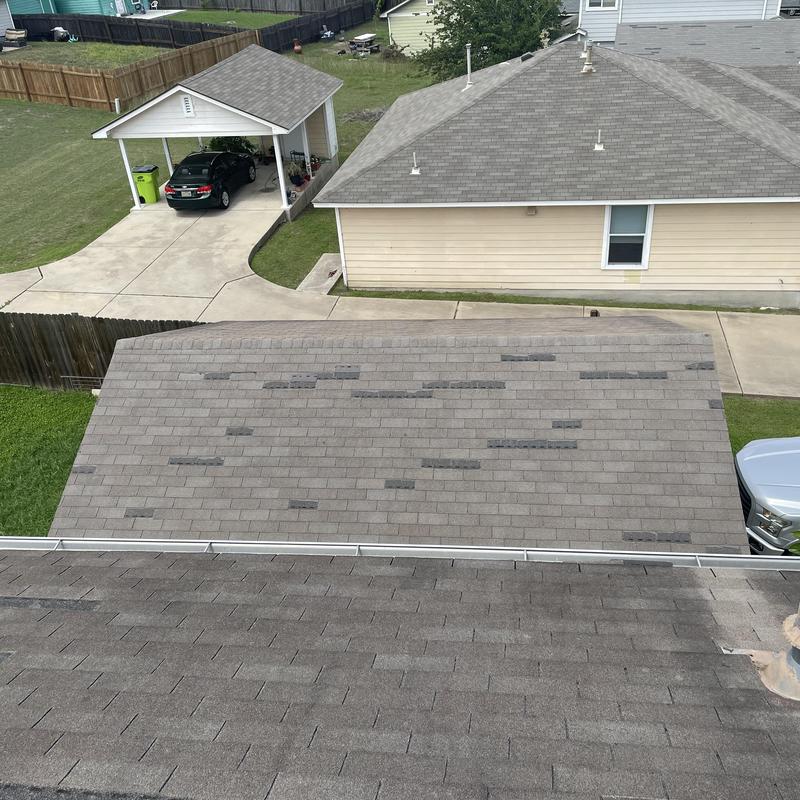 Roof shingles with missing patches on garage roof