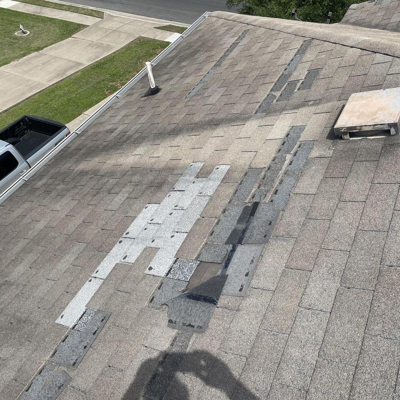 Asphalt roof shingles with missing and replaced patches