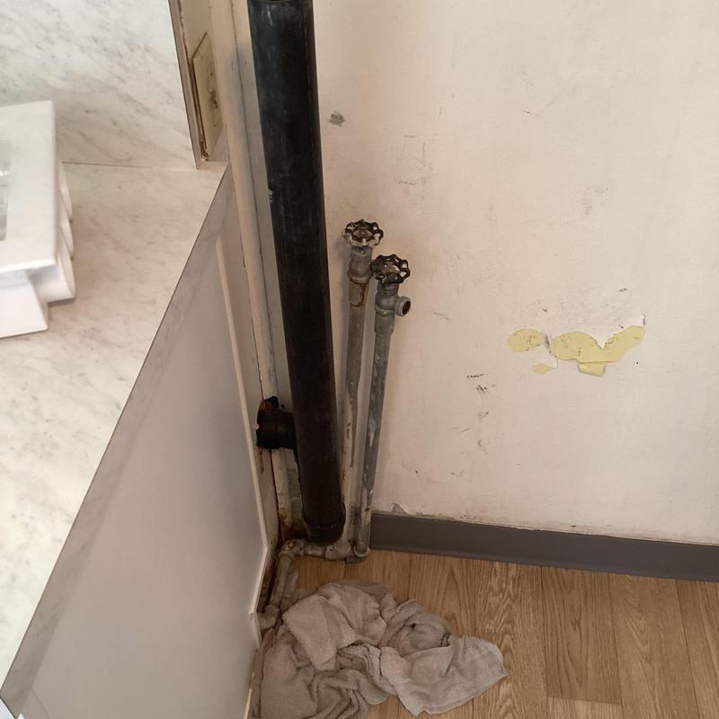 Washing machine plumbing pipes and drain lines near wall