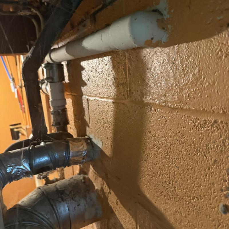 PVC drain pipe and vent connections on basement wall PVC drain pipe and vent connections on basement wall