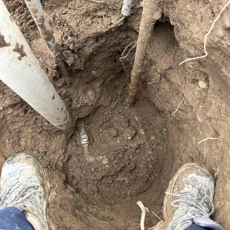 Well head excavation showing pipes and corroded hydrant