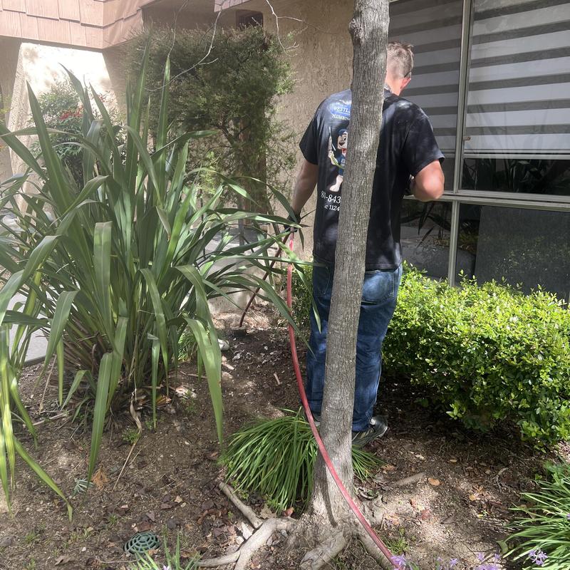 Main line sewer hydro jetting with red hose outdoors Main line sewer hydro jetting with red hose outdoors