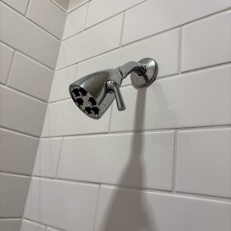 Shower head chrome installation on tiled wall