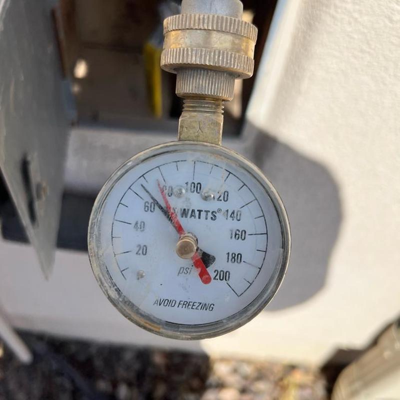 Pressure regulator valve gauge showing 68 PSI water pressure