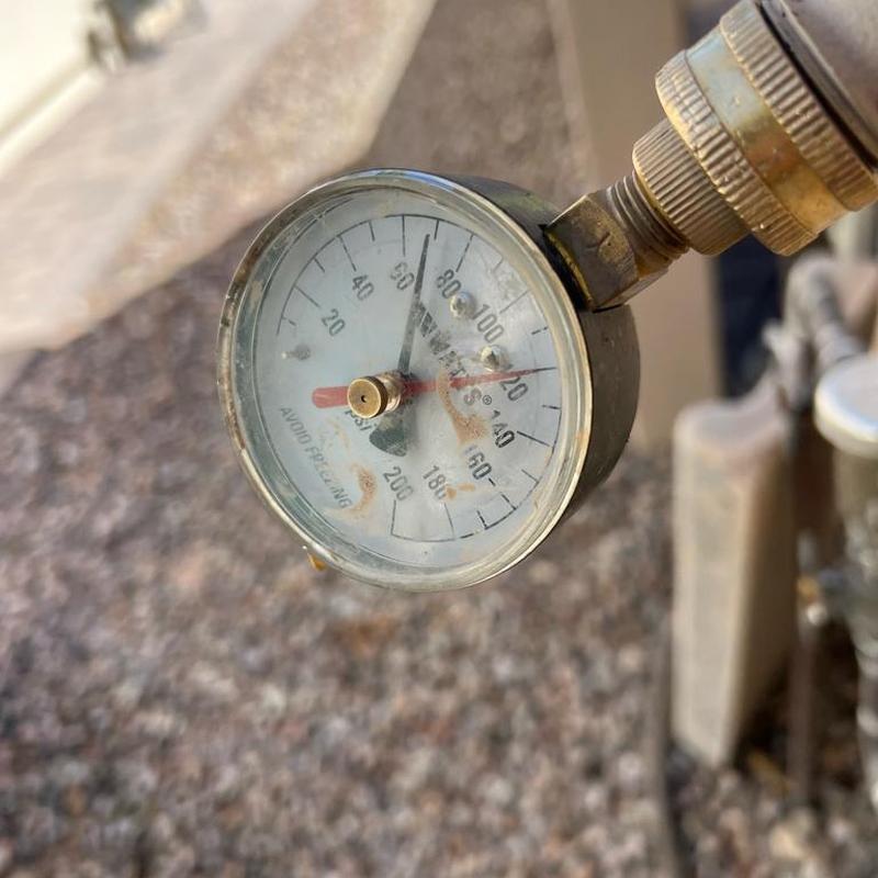 Pressure gauge on water line valve outdoors
