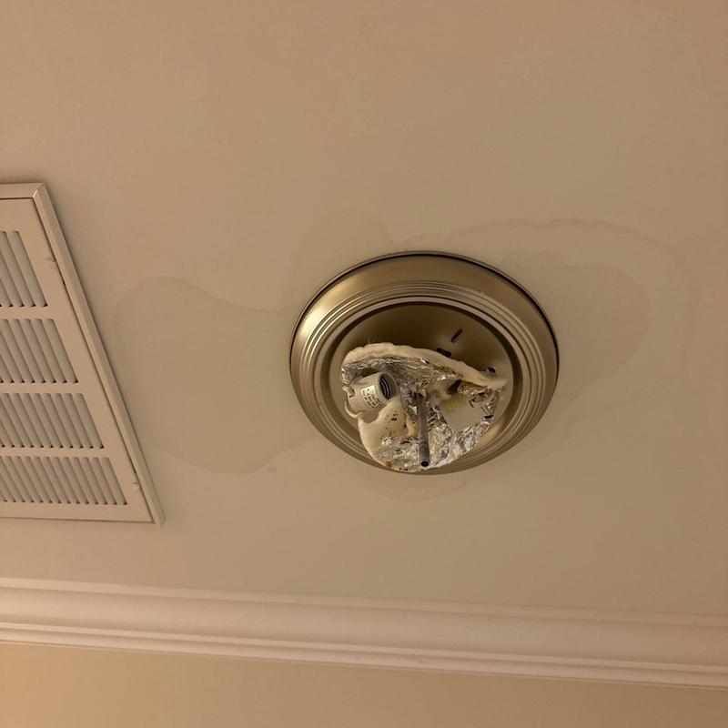 Ceiling light fixture with water stain and damage