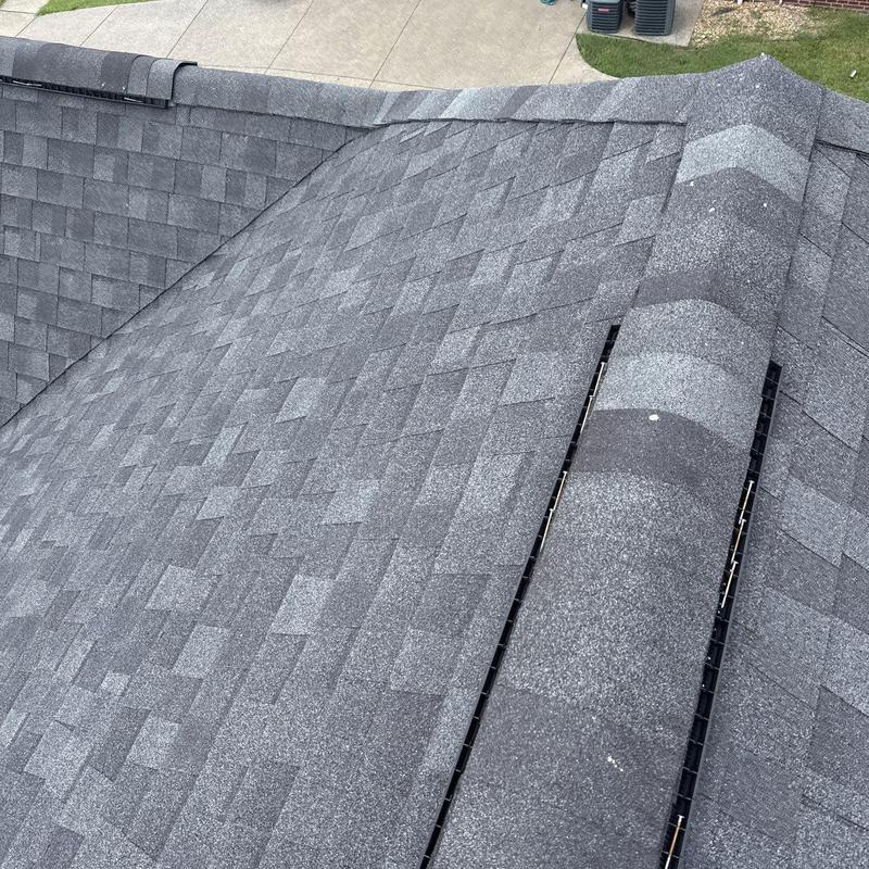 Asphalt shingle roof with ridge vent and hail damage