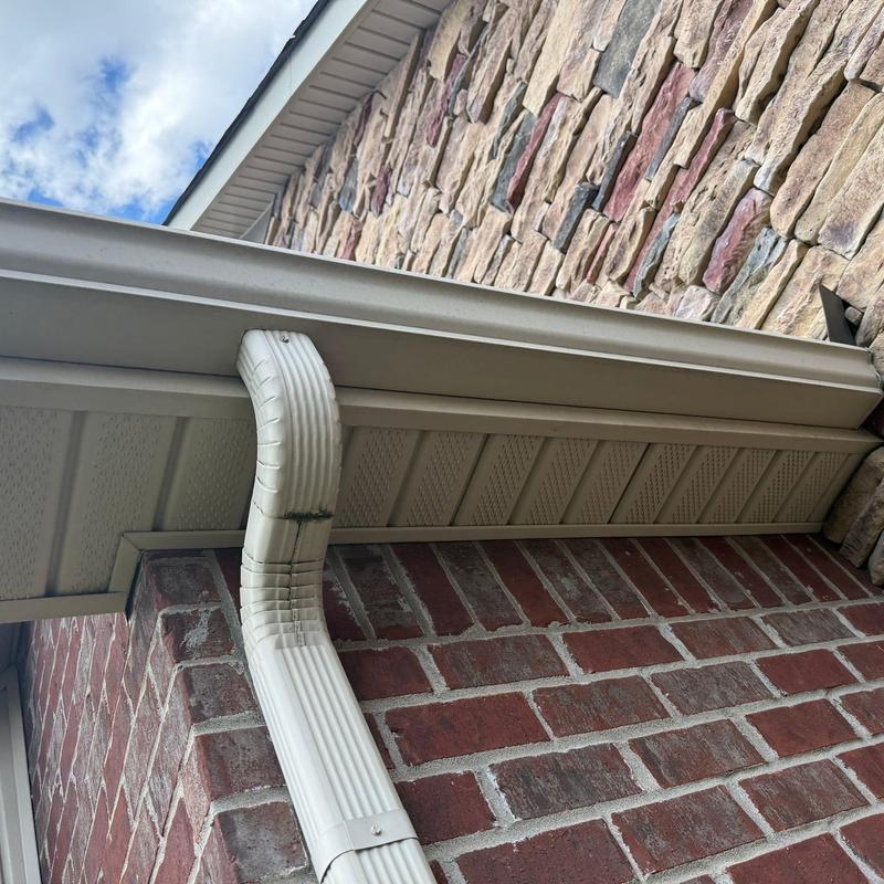 Seam gutter downspout connection on brick and stone wall