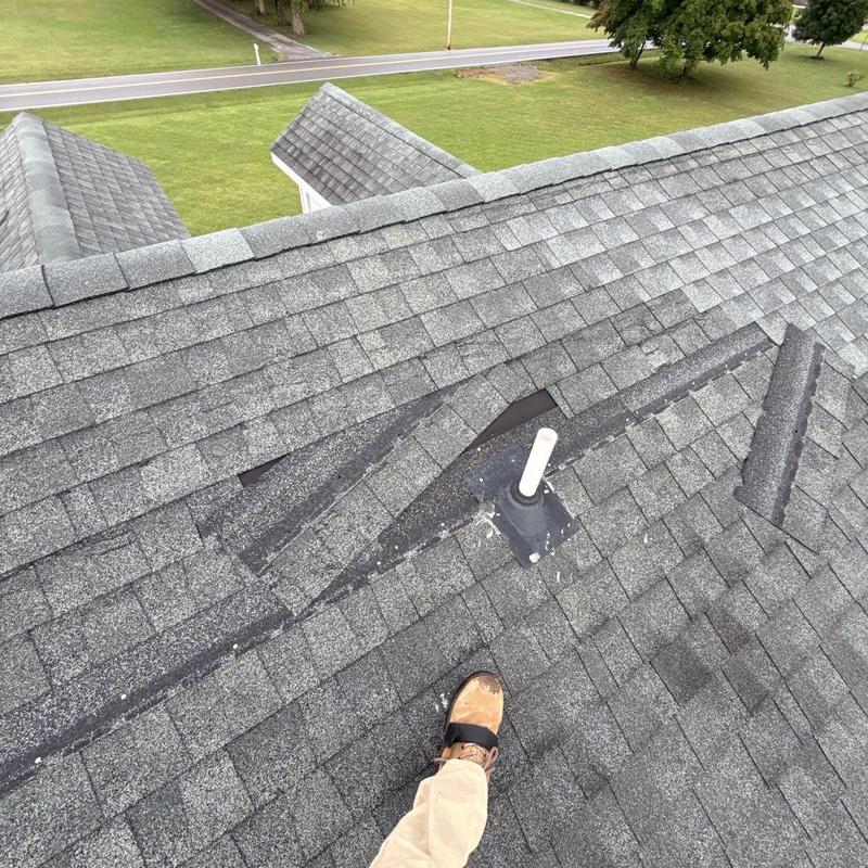 Roof shingles with hail damage near pipe flashing