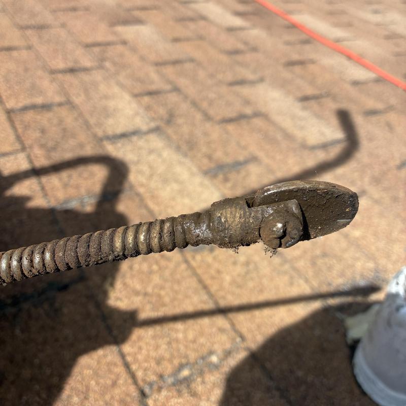 Drain cleaning snake with attached cutting blade tip