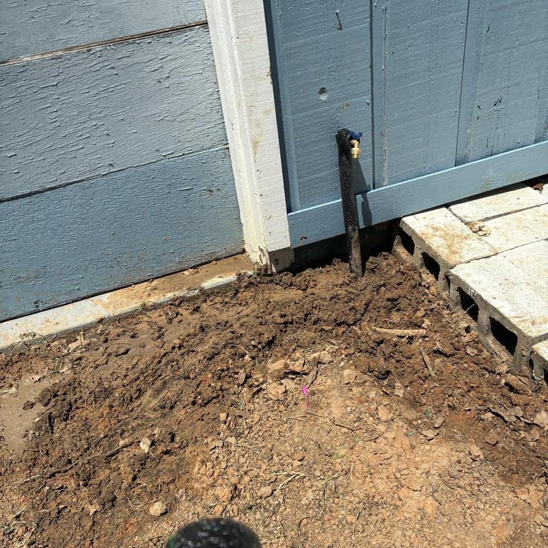 Back porch hose bib with soil and cinder blocks