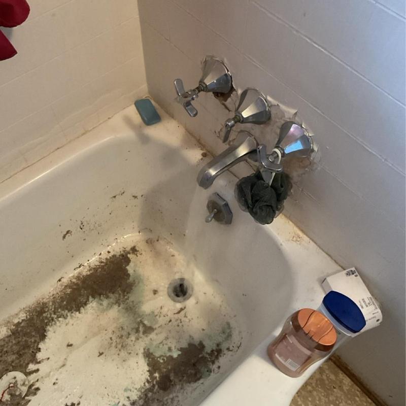 Bathtub faucet and dirty tub with water running Bathtub faucet and dirty tub with water running
