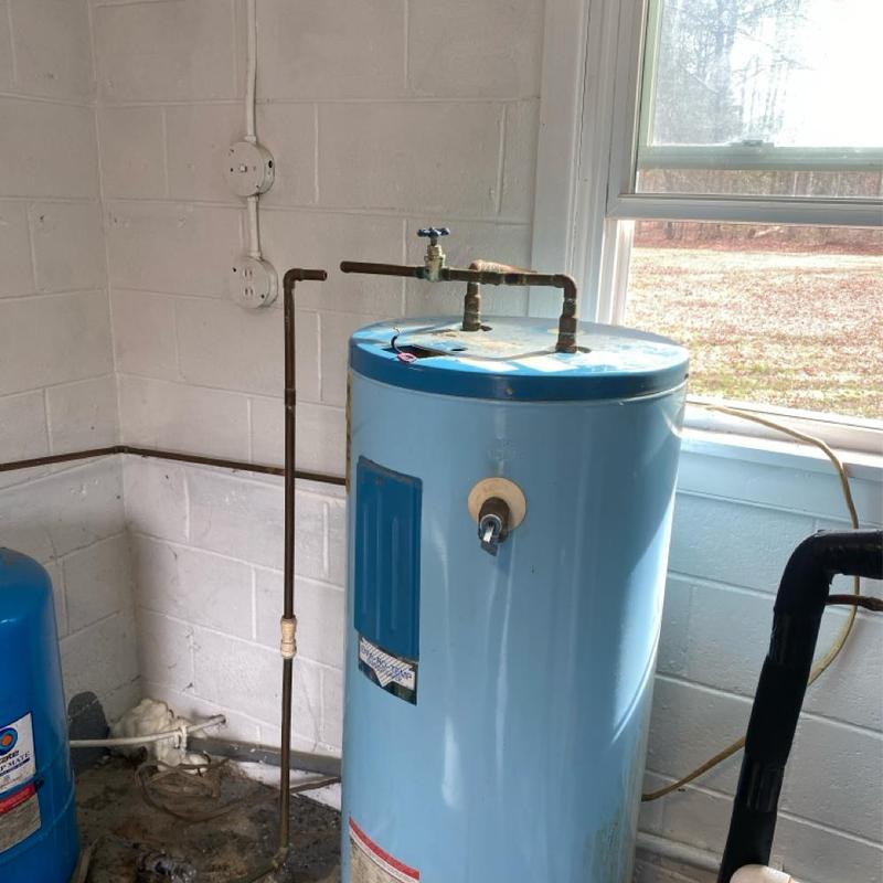 Electric water heater with copper piping next to window Electric water heater with copper piping next to window
