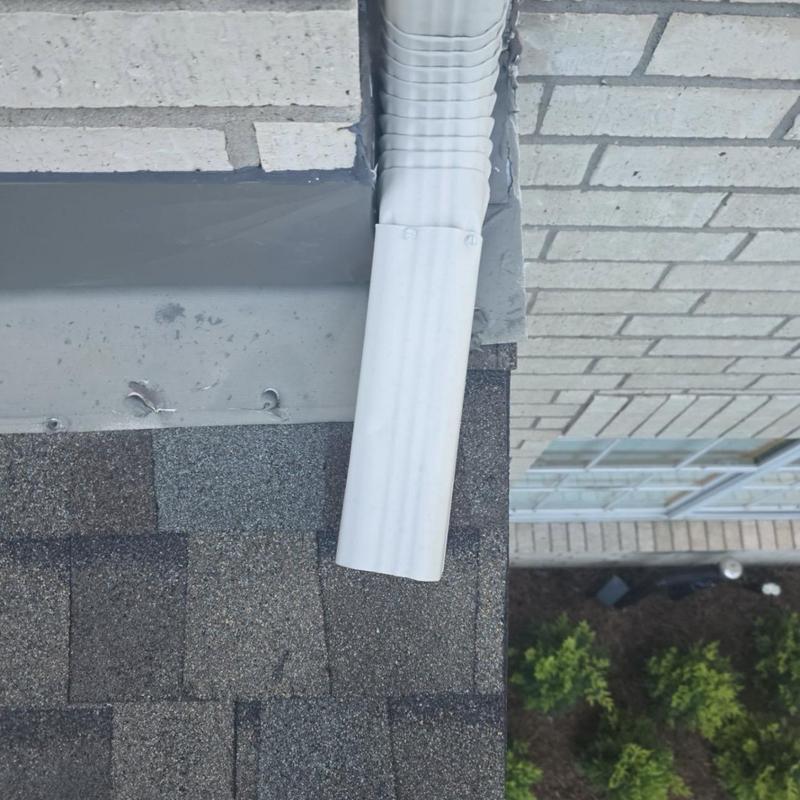Downspout extension above asphalt shingle roof edge Downspout extension above asphalt shingle roof edge