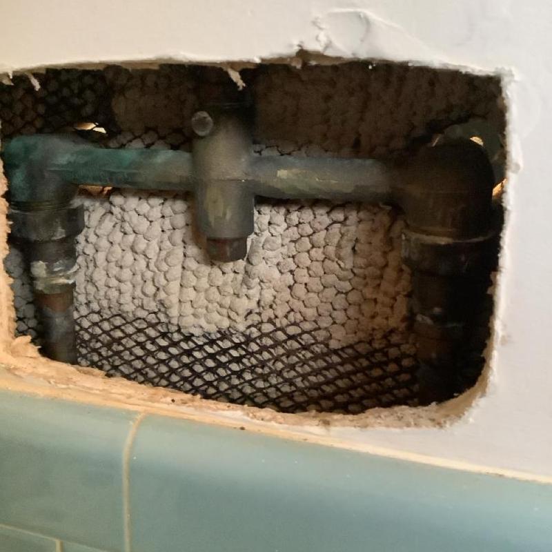 Two-handle shower faucet plumbing exposed behind wall Two-handle shower faucet plumbing exposed behind wall