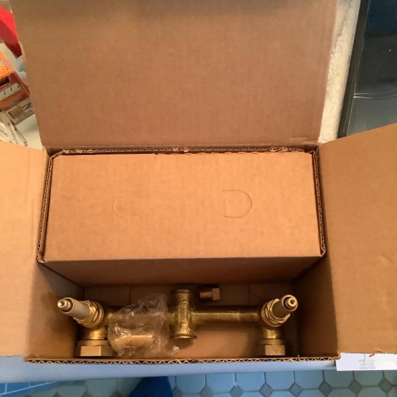 Two-handle shower faucet valve inside cardboard box Two-handle shower faucet valve inside cardboard box