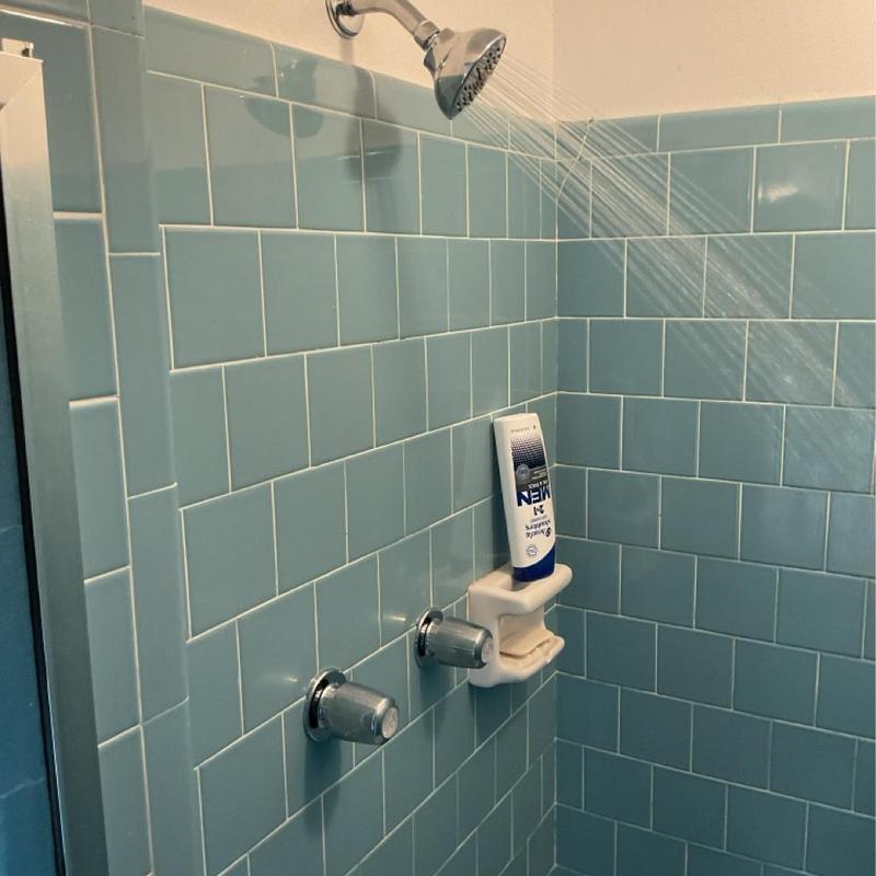 2-handle shower faucet with running showerhead in tiled shower 2-handle shower faucet with running showerhead in tiled shower