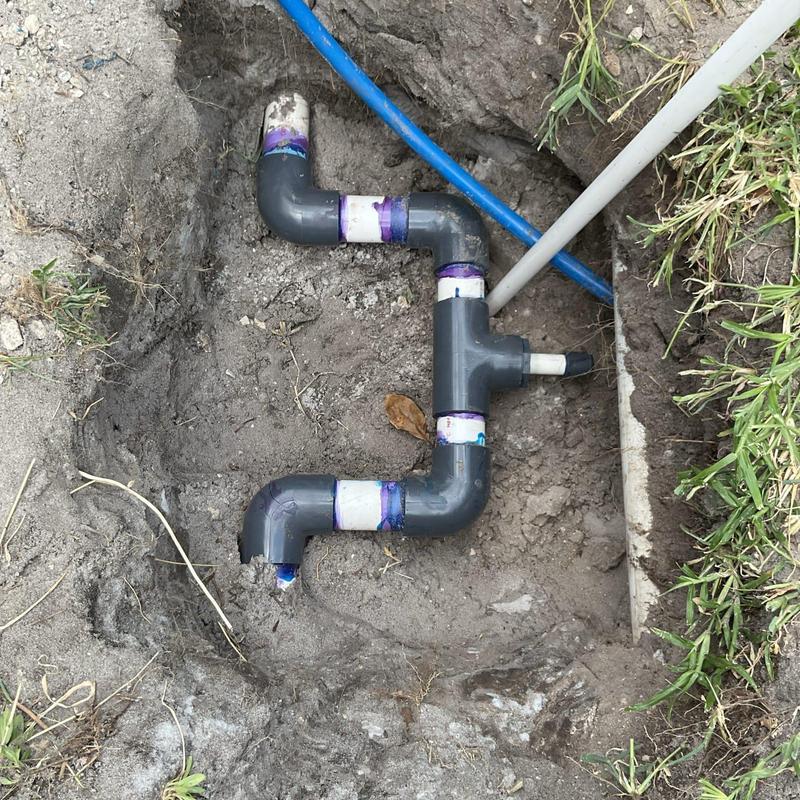 Main water line with PVC pipe fittings in soil trench