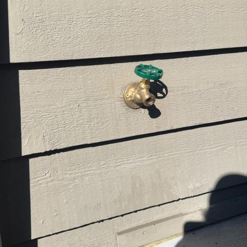 Outdoor spigot and vacuum breaker on house siding