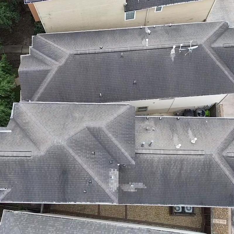 Asphalt shingle roof with visible patch and wear areas
