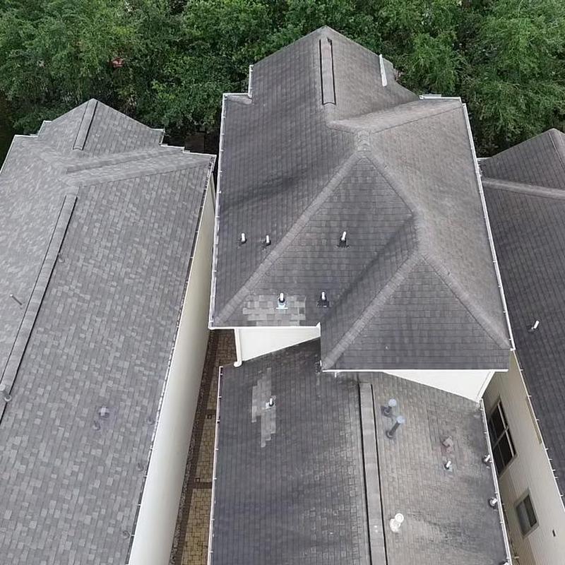 Asphalt shingle roof with patch repairs on 3-story home