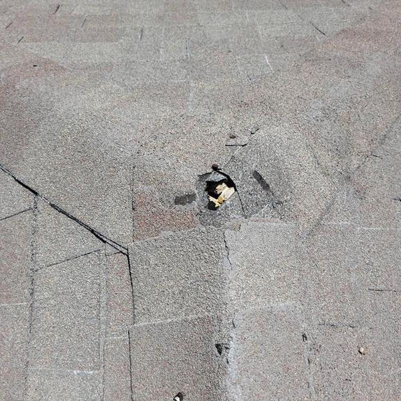 Asphalt shingle roof with damaged nail hole