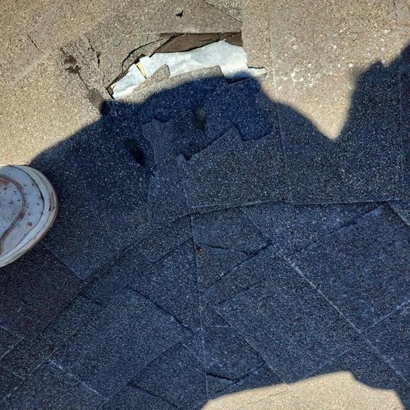 Roof shingles with hole and damage during inspection