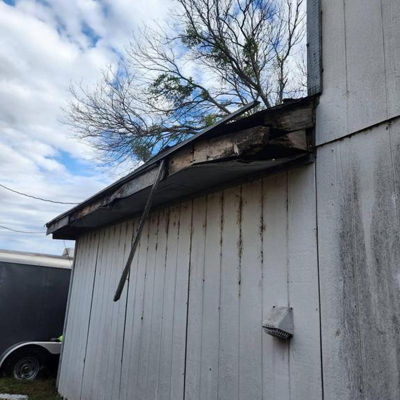 Shed roof edge with damaged fascia and wood decay