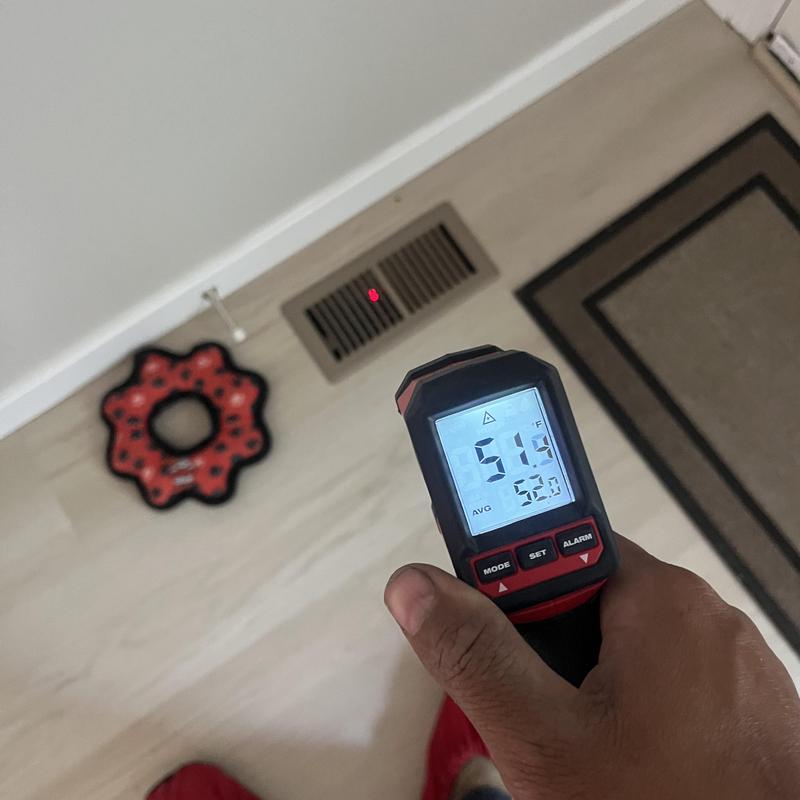 Thermometer measuring temperature at floor vent