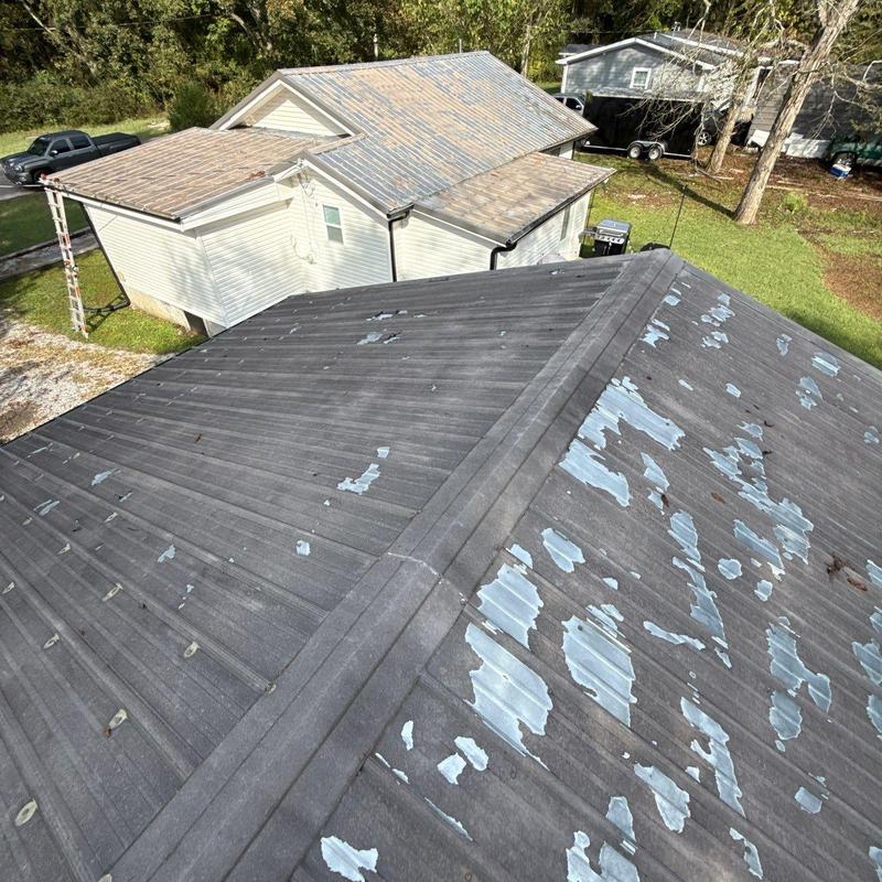 Metal roofing with extensive paint peeling and weathering damage