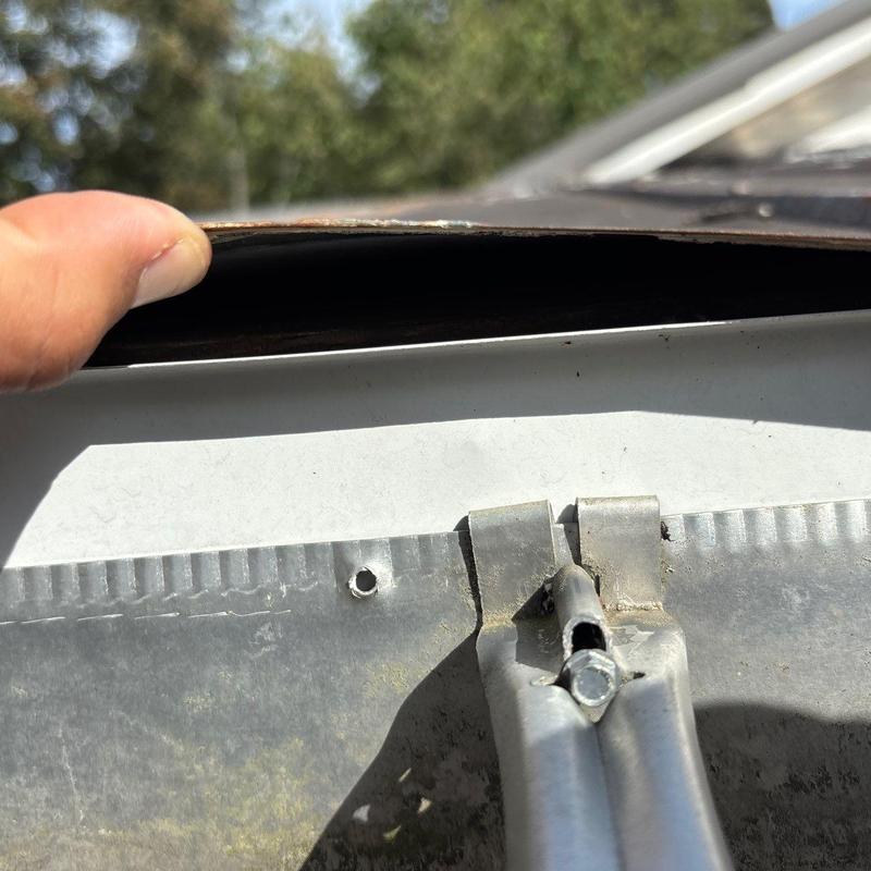 Roof flashing lifted showing potential hail damage and fastener hole