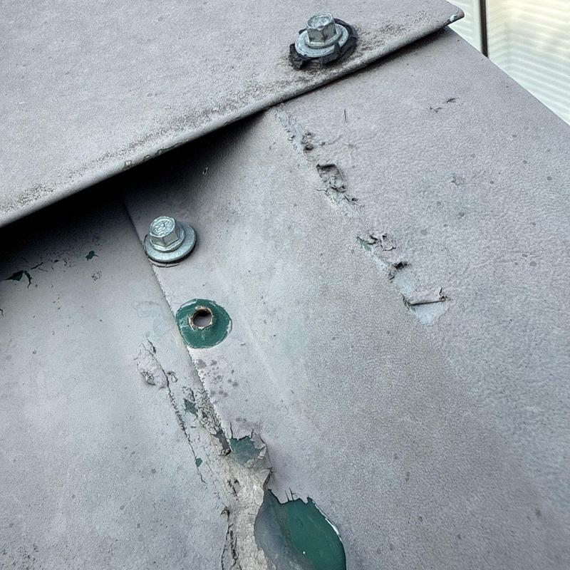 Metal roof flashing with corrosion and missing fastener