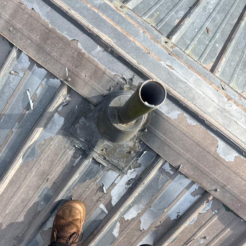 Metal roof vent pipe flashing with corrosion and peeling paint