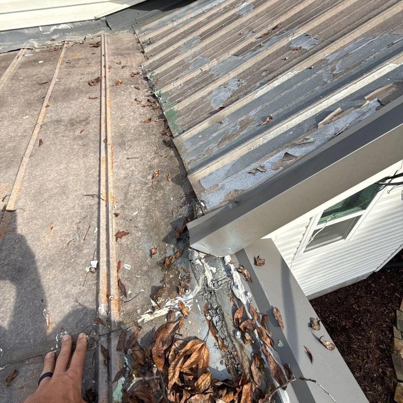 Metal roof flashing with hail damage and debris buildup