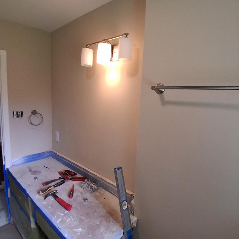 Towel rack and light fixture installation tools on counter
