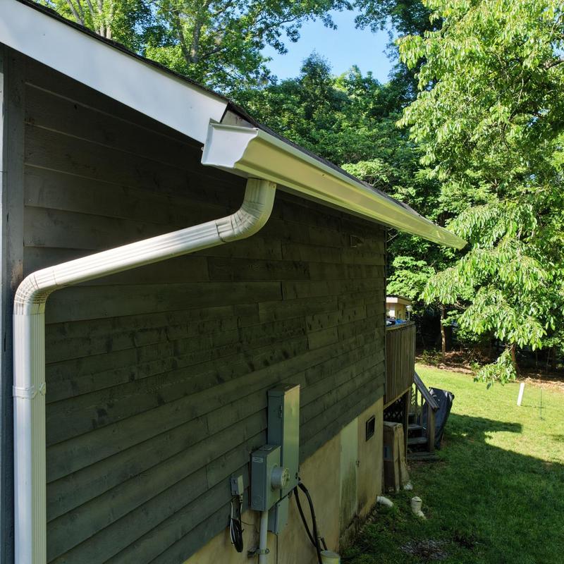 White gutter system with downspout on house exterior