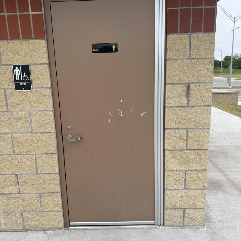 Restroom door with damaged exterior and handle Restroom door with damaged exterior and handle