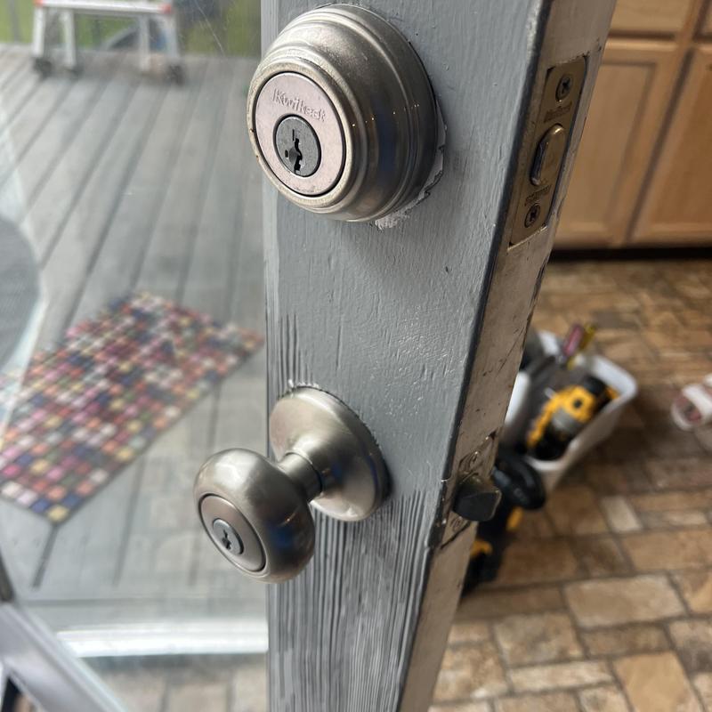 Door knob lock with rekeyed deadbolt on gray door Door knob lock with rekeyed deadbolt on gray door