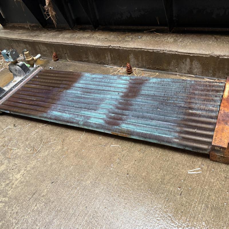 Heat exchanger coil removed and resting on concrete floor