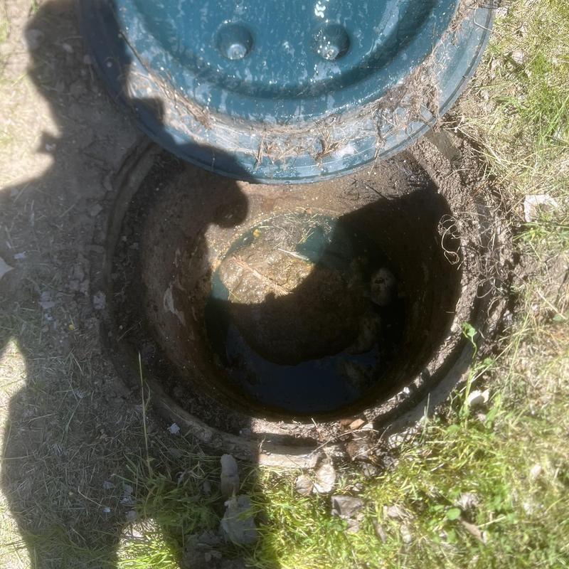 Septic tank opening with high liquid levels outdoors