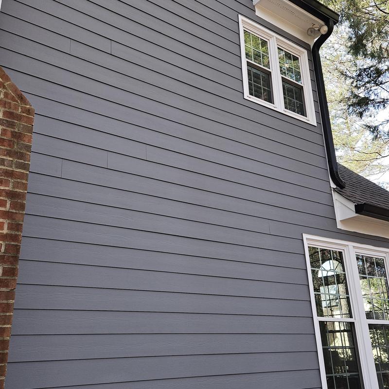 Gray horizontal lap siding installation on house exterior