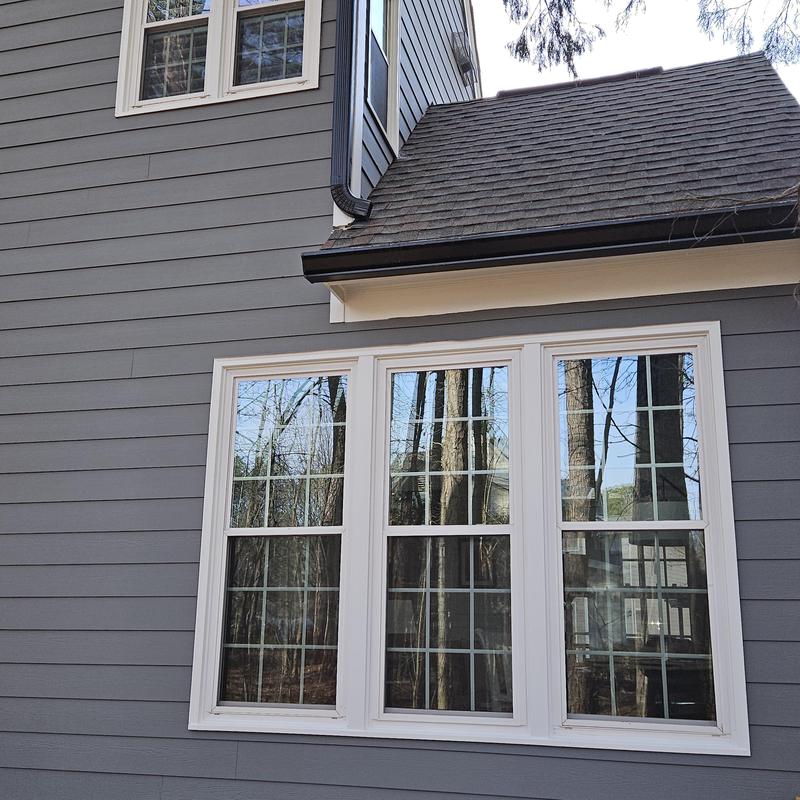 Vinyl siding and triple window installation on house exterior