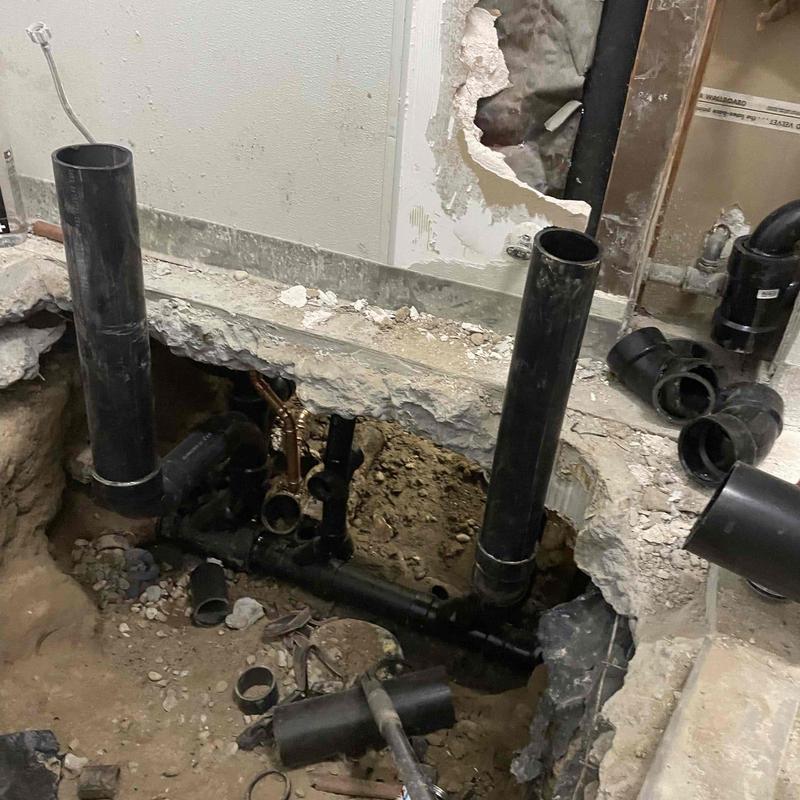 ABS waste pipes exposed in bathroom floor repair site
