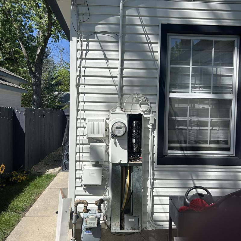 Main electrical service panel beside gas meter outdoors