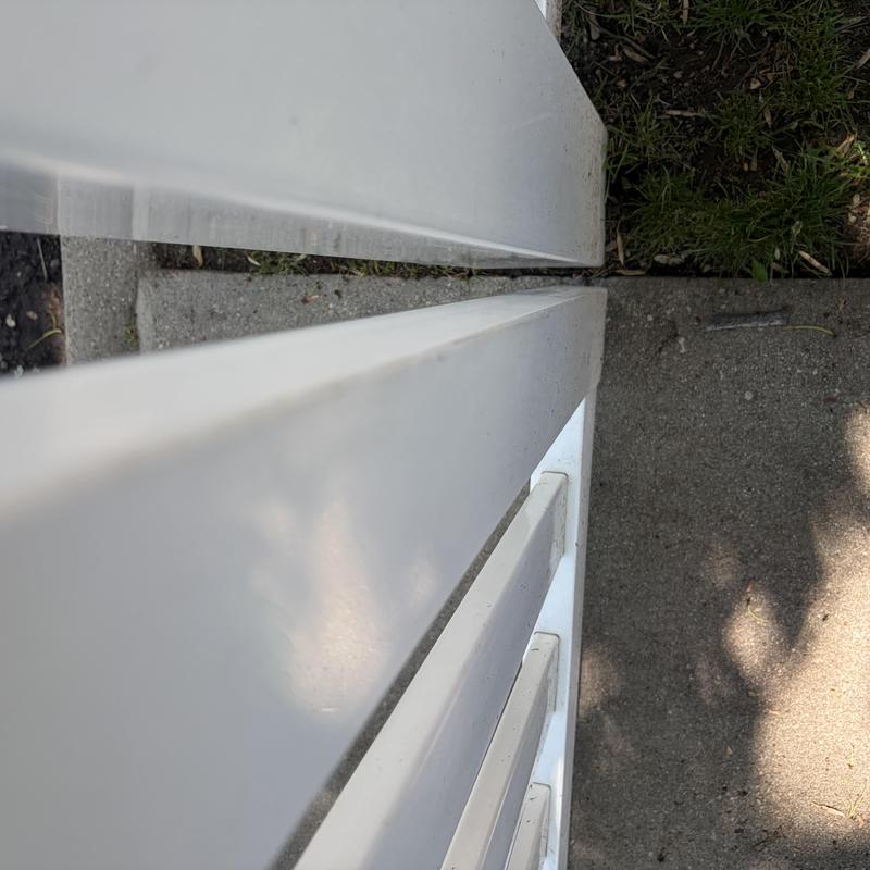 Vinyl fence panels close-up with concrete and grass background