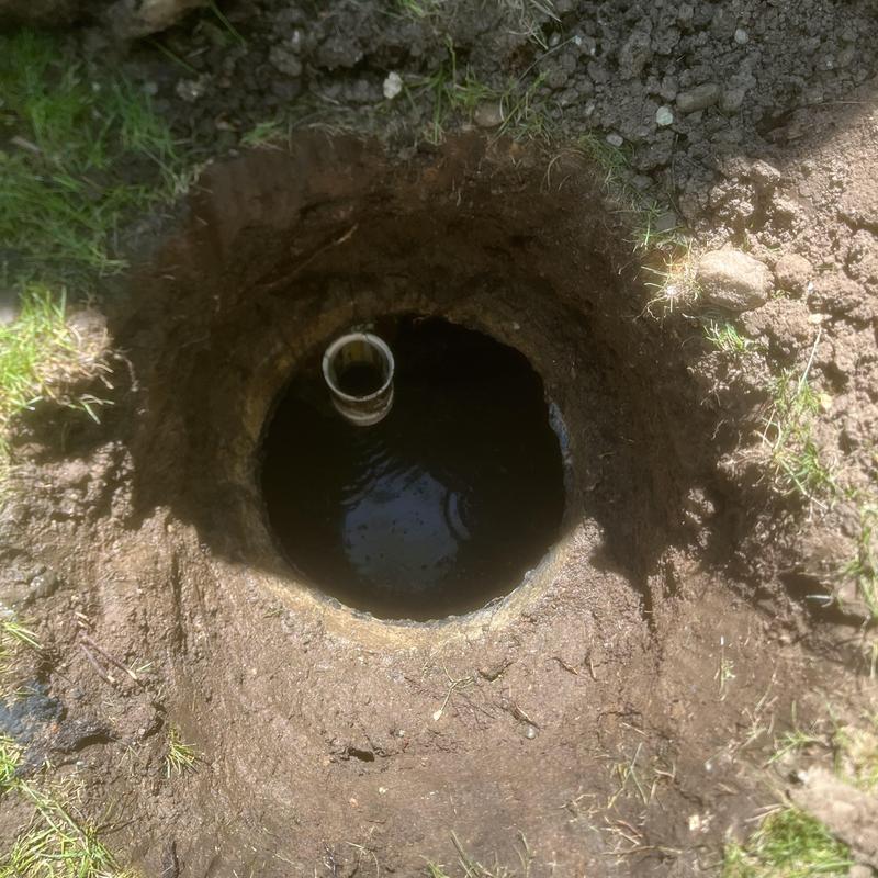 Septic tank opening with water and inspection pipe