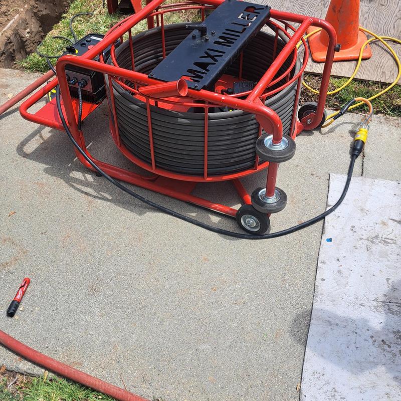 Clay lateral sewer camera inspection reel on concrete driveway