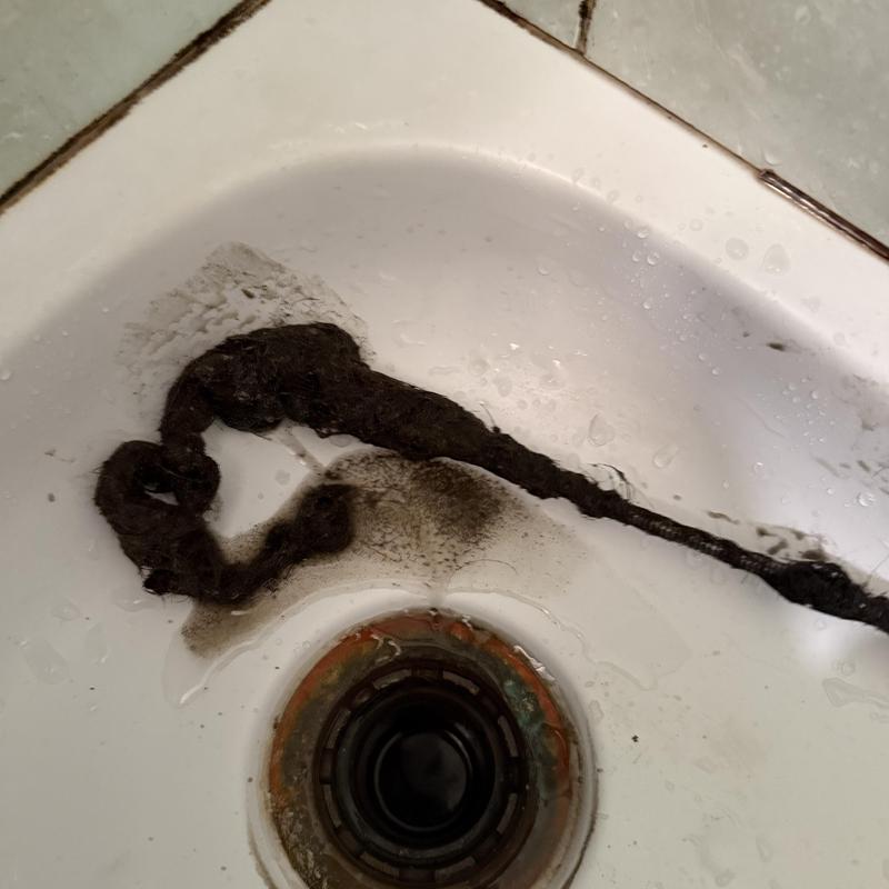 Basin sink drain with removed hair clog and debris Basin sink drain with removed hair clog and debris