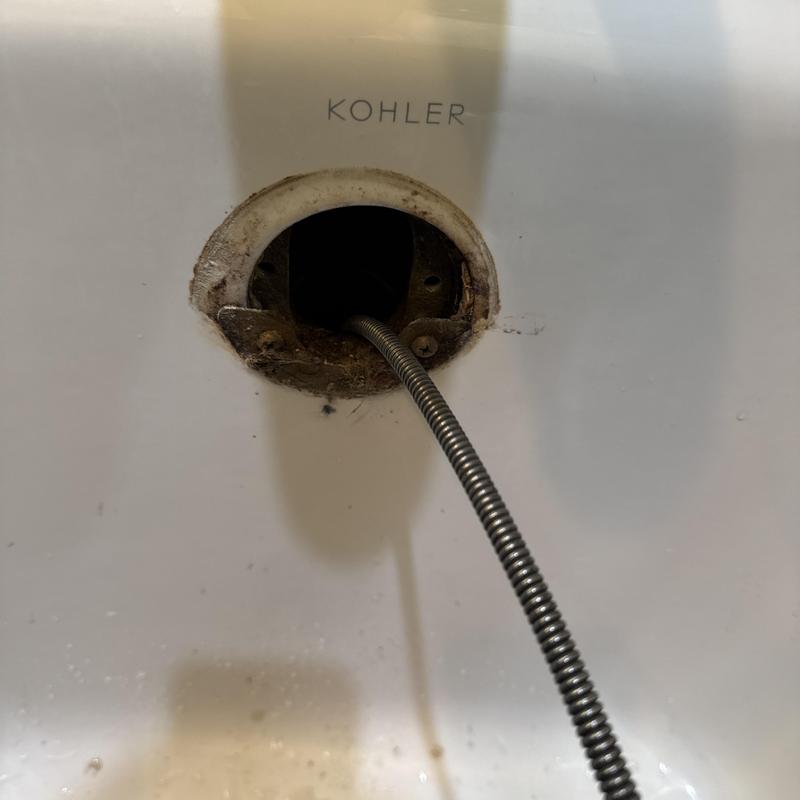 Basin sink drain with cleaning snake inserted Basin sink drain with cleaning snake inserted