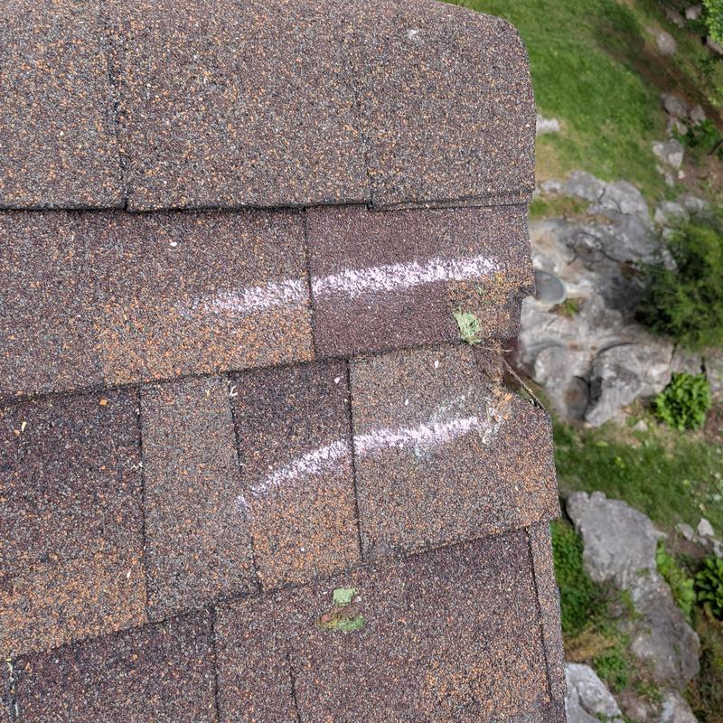 Asphalt roof shingles with impact marks and chalk lines Asphalt roof shingles with impact marks and chalk lines